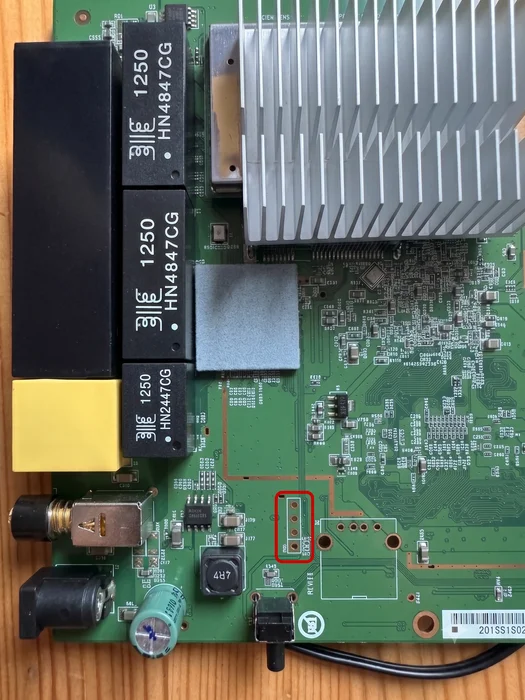 Component side of the DIR-855L A1 circuit board, showing its heatsink, ports, and UART connection area.